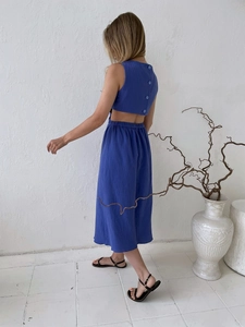 Detail view of the back button closure and waist cutout on a navy textured maxi dress