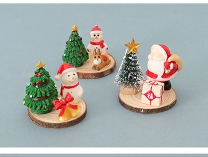 Close-up of miniature Christmas figurines with Santa and reindeer on wooden bases