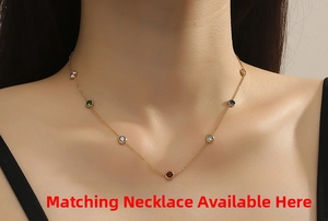 Macro shot of gold necklace with colorful round cut gemstones worn by model
