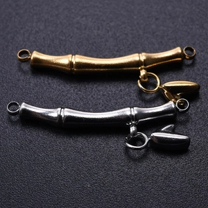 Close-up of bamboo-style 18k gold and silver jewelry links with heart charms