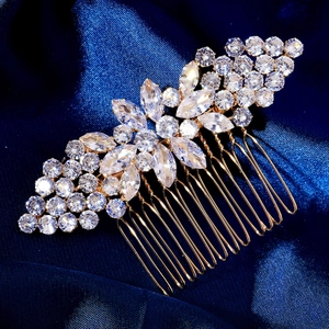 Elegant gold flower hair comb with zircon crystals on a dark blue silk background