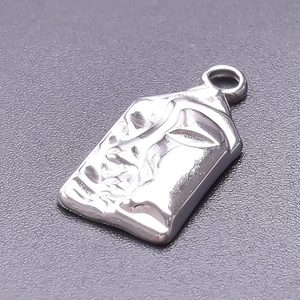 Macro shot of silver embossed face pendant in stainless steel with polished metallic finish