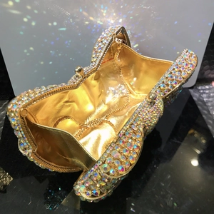 Top view of open golden bow clutch with colorful rhinestones and gold lining