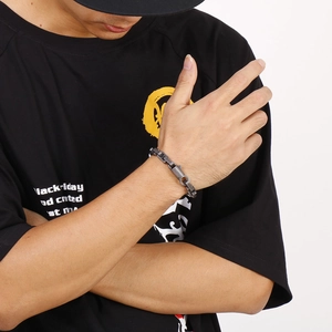 Detail of industrial style metal chain bracelet with geometric links on wrist