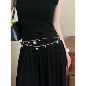 Detail of silver double-layer waist chain with pearls and flower charms on black dress