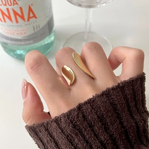 Irregular gold wave ring with minimalist abstract design worn on a finger