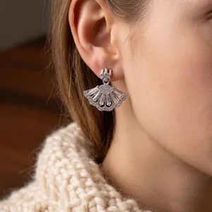 Sparkling silver fan-shaped drop earrings with zircon crystals on a female model