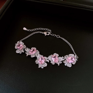 Detail view of silver floral bracelet with pink zircons in a textured jewelry gift box