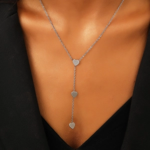 Dettaglio di una collana a Y d'argento con tre ciondoli a cuore in acciaio lucido fine