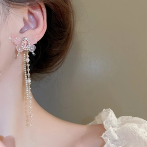 Detail of pink butterfly earrings with diamond tassel and long pearl drop chains