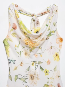 Detail eines Halfterkleides mit Wasserfallausschnitt und gelb-orangefarbenem Blumenmuster