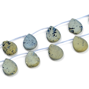 Macro shot of dark golden-green teardrop gemstones with natural mineral texture