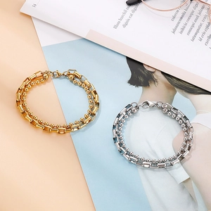 Dual-layer stainless steel bracelet featuring bead and long box chain in gold and silver