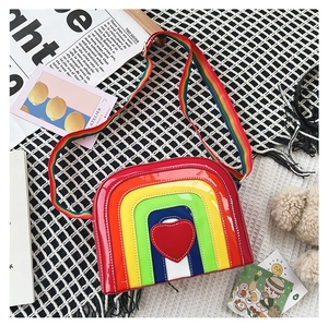 Detail of colorful rainbow heart crossbody bag with glossy finish and braided strap