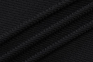 Macro shot of black ribbed knit fabric texture with vertical stripes and soft drape