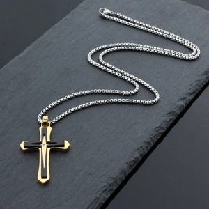 Hip hop two-tone gold and black stainless steel cross pendant with silver chain on rock