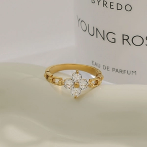 Macro detail of gold four-leaf clover ring with zircon inlay and chain style band