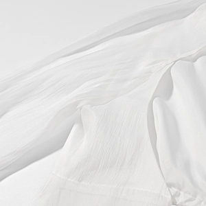 Detailed macro view of white textured fabric showing breathable and pleated material