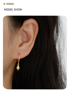Detailed model shot of gold s925 silver hoop earrings with sparkling shell pendants