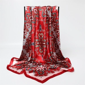 Détail d'un foulard en satin rouge à motif paisley montrant la texture soyeuse
