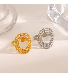 Detailed close-up of gold and silver layered oval rings with textured spiral finish