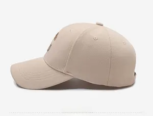 Detailed side view of beige baseball cap featuring textured fabric and dark side embroidery