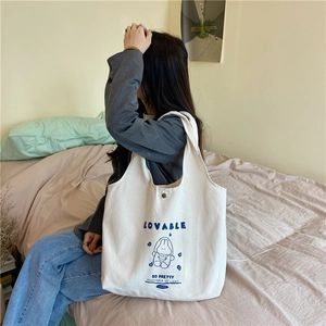 Détail d'un sac cabas en toile crème avec imprimé lapin bleu et fermeture à pression métal