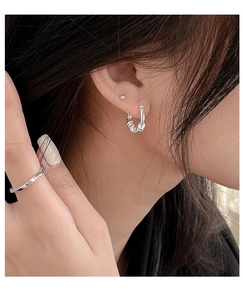 Close-up of S925 sterling silver twisted earrings and engraved IN TIME ring on model