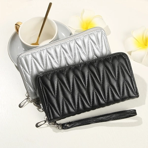 Detail of black and silver zip wallets with V-shaped quilted texture and wrist strap