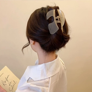 Matte translucent white large claw clip worn by a model in an elegant lifestyle setting