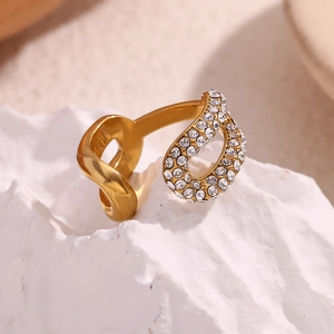 Macro di un anello placcato oro 18 carati con strass incastonati su roccia bianca