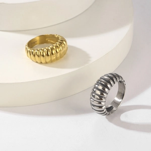 Macro detail of gold and silver stainless steel rings with ribbed texture on tiered stands