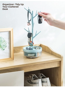 Detail of light blue jewelry tree organizer with rotating base on wooden shelf