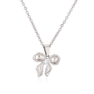 Silver bow pendant necklace with round cubic zirconia on fine chain, white background