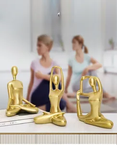 Close-up of three golden yoga figurines in various poses for modern home decor