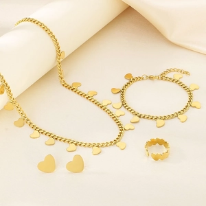 Close-up of gold titanium steel jewelry set featuring heart pendants and open heart ring