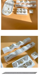 Close-up of minimalist white plaster jewelry tray and ring stands for boutique display