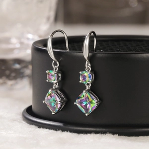 Macro detail of silver drop earrings with iridescent rainbow cushion-cut zircon stones