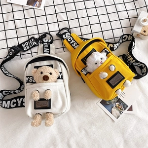 Detail of canvas chest bags featuring 3D plush bear and sheep dolls with logo straps