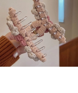 Close-up of handmade knit flower hair claw clip in beige, pink and muted red shades