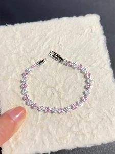 Detail of pink and white floral zircon bracelet with silver clasp on white background