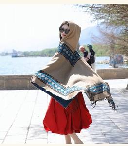 Bohemian hooded poncho with ethnic pattern and tassels for travel photography use.