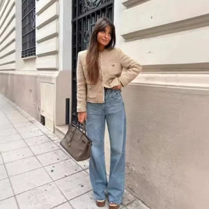 Elegant beige tweed short jacket paired with high-waist blue wide-leg jeans in street style