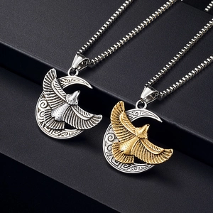 Detailed view of silver and gold eagle pendants on moon bases with box chains