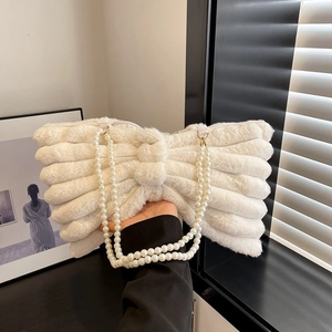 Detail of white plush bow shoulder bag with elegant double-row faux pearl handle