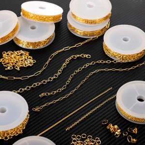 Detailed macro view of gold-plated jewelry chains on rolls with lobster clasps