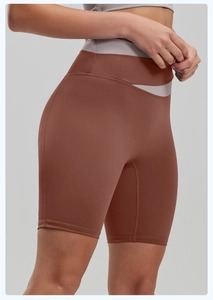 Detail of high-waist yoga shorts showing the criss-cross waistband and stitched seams