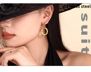 Close-up of geometric textured gold interlocking hoop earrings in stainless steel