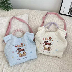 Detail of heart-quilted dog embroidery handbag with colorful woven handles and pink strap