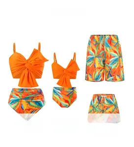 Family matching swimwear featuring orange twist bikini sets and tropical leaf print swim trunks